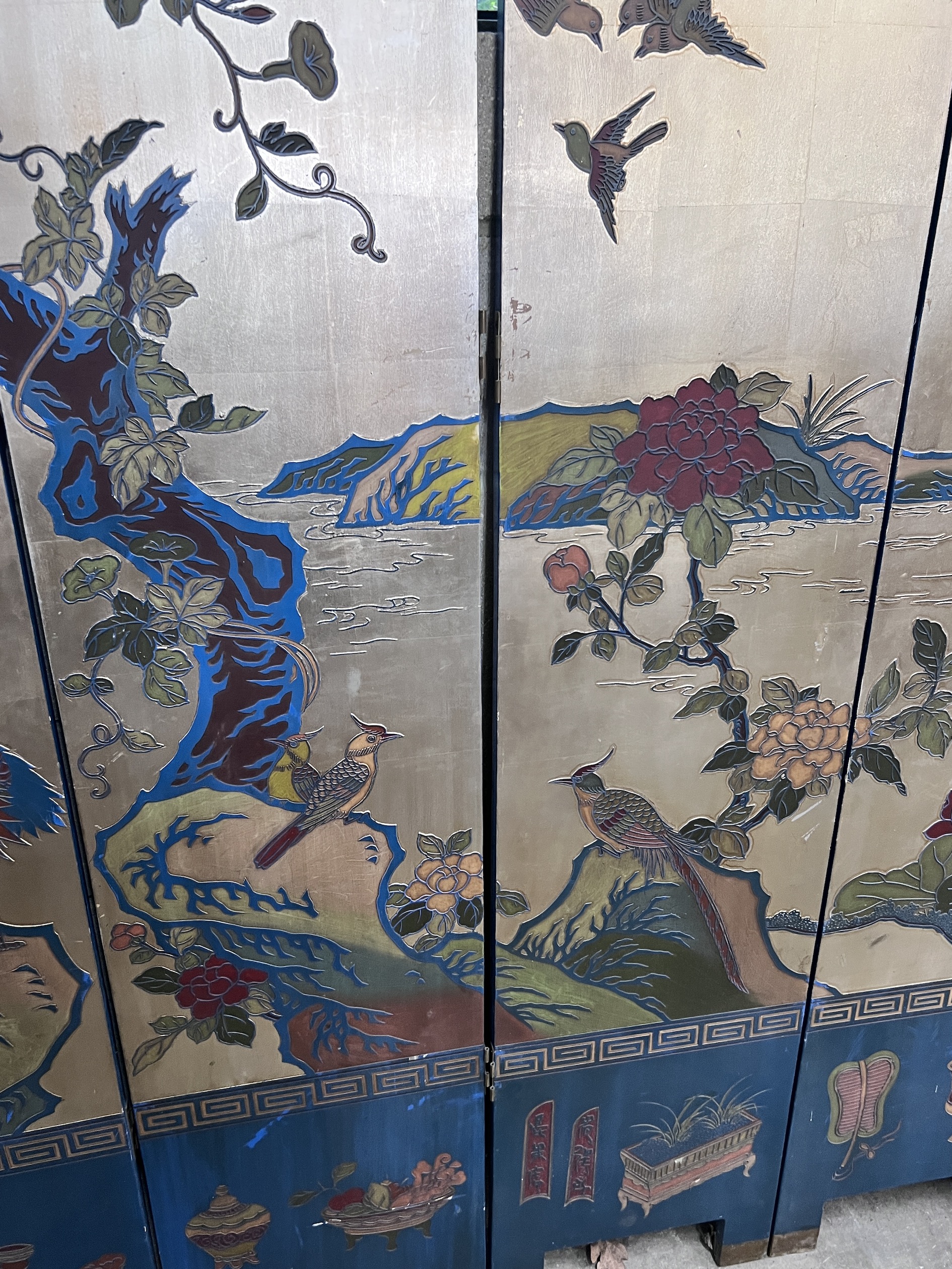 A Chinese lacquered eight fold screen decorated with exotic birds among flowering trees, each panel width 40cm, height 244cm (no fixing clips)